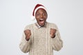 Funny christmas african man in red hat over grey background Royalty Free Stock Photo