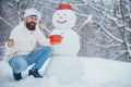 Funny Christmas chef cook. Christmas preparation - funny bearded man with snowman. Man is happy about the new year