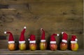 Funny christmas greeting card with seven red santa hats on apple Royalty Free Stock Photo