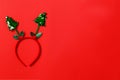 Funny christmas tree headband on red background. Festive minimal