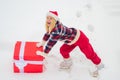 Funny Christmas woman and a big gift box. Funny woman holding a big Christmas present. Crazy Christmas girl pushes a big Royalty Free Stock Photo