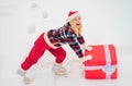 Funny Christmas woman and a big gift box. Funny woman holding a big Christmas present. Crazy Christmas girl pushes a big Royalty Free Stock Photo