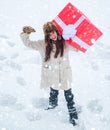 Funny Christmas woman and a big gift box. Service women with big gift box. Happy woman standing on white snow background Royalty Free Stock Photo