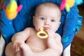 Funny chubby baby with teether in mouth