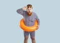 Funny chubby man in swimsuit and inflatable ring looking at something in surprise Royalty Free Stock Photo