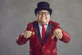 Funny chubby rich senior man in shiny jacket and black top hat dancing and smiling Royalty Free Stock Photo