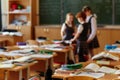 Funny classmates. Three cute little children communicate and discuss something standing near the blackboard . Background image