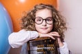 Funny, clever curly teen girl in glasses with wooden abacus on t Royalty Free Stock Photo