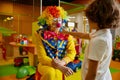 Funny clown animator and boy fooling around playing at indoor playroom