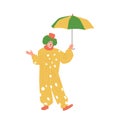 Funny clown in cute stage costume standing under umbrella, circus show entertainer character Royalty Free Stock Photo
