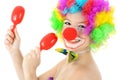 Funny clown with make up makes music with toy rattles in studio Royalty Free Stock Photo