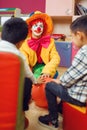 Funny clown play with cheerful children together