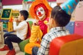 Funny clown play with cheerful children together