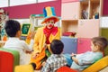 Funny clown play with cheerful children together