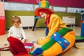 Funny clown play with joyful little girl together Royalty Free Stock Photo