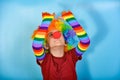 Funny clown in a wig with a red nose is trying to grope the wall Royalty Free Stock Photo