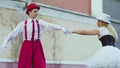 Funny comic couple on stilts dancind cool near building