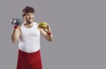 Funny comic overweight man with dumbbell and hamburger isolated studio portrait