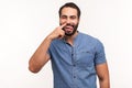 Funny comical man with beard picking finger to nose and showing tongue, looking at camera with smile, having fun, fooling around,