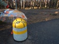 Funny concrete protective column under an umbrella on a bike path Royalty Free Stock Photo