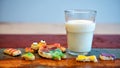 Funny cookies and a glass of milk on wooden table Royalty Free Stock Photo