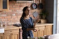 Joyful millennial latina woman juggle with cherry tomatoes at kitchen