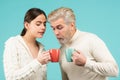 Funny couple drinking tea. Morning cup, coffee mug, people on isolated background with copy space. Surprised people hold