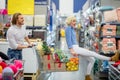 Young happy man pushing shopping trolley with his girfriend in mall Royalty Free Stock Photo