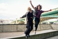 Funny couple junping near the Southwark bridge over River Thames, London Royalty Free Stock Photo