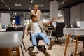 Funny couple riding office chair at shop Royalty Free Stock Photo