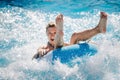 Funny girl taking a fast water ride on a float splashing water. Summer vacation concept.