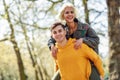 Funny couple in a urban park. Boyfriend carrying his girlfriend on piggyback. Royalty Free Stock Photo