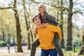 Funny couple in a urban park. Boyfriend carrying his girlfriend on piggyback. Royalty Free Stock Photo