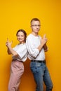 Funny couple woman and man posing against bright orange studio wall background Royalty Free Stock Photo