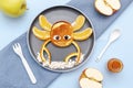 Funny crab face shape snack from pancake, orange,apples,honey on plate. Cute kids childrens baby`s sweet dessert, healthy Royalty Free Stock Photo