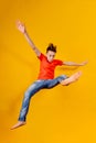 Funny and crazy boy jumps up on a yellow background, wide angle photo Royalty Free Stock Photo