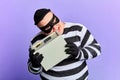 Funny crazy burglar trying to open safe with teeth Royalty Free Stock Photo