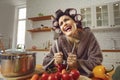 Funny crazy cheerful woman standing in kitchen and holding kitchenware Royalty Free Stock Photo