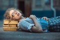 Funny crazy girl student with glasses lying on a pile of books Royalty Free Stock Photo