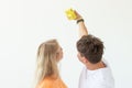 Funny crazy young couple blonde girl and a hipster guy taking a selfie on a vintage yellow film camera posing on a white Royalty Free Stock Photo