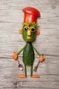 Funny cucumber chief made on wooden background