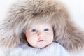 Funny curious baby girl in a huge winter hat Royalty Free Stock Photo