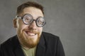 Closeup portrait of a funny crazy nerd in round frame glasses smiling at the camera Royalty Free Stock Photo