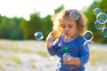 Horizontal defocused photo of funny curly-haired girl with soap bubbles Royalty Free Stock Photo