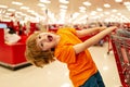 Funny customer boy child holdind trolley, shopping at supermarket, grocery store. Cute boy child with shopping trolley Royalty Free Stock Photo