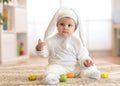 Cute baby child in rabbit costume sittng on froor in nursery