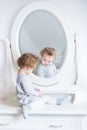 Funny cute baby girl watching her reflection in a white bedroom Royalty Free Stock Photo