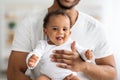 Funny Cute Black Little Infant Baby Relaxing In Father& x27;s Hands At Home Royalty Free Stock Photo