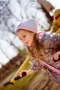 Funny cute blond little girl having fun riding a swing looking at copy space & happy smiling in spring or autumn park Royalty Free Stock Photo