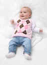 Funny cute female newborn dressed in pink sweater and jeans on white fur blanket. Infant baby girl with pink sweater and jeans. Royalty Free Stock Photo